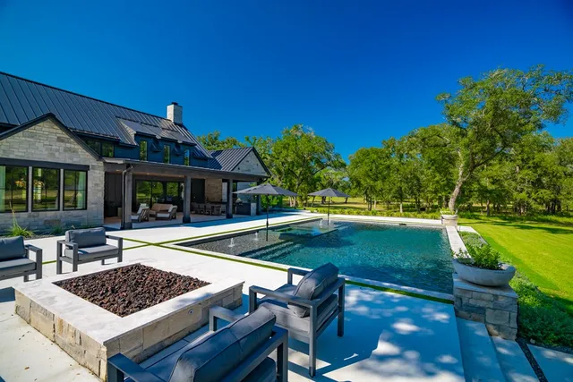 a view of a house with swimming pool and sitting area