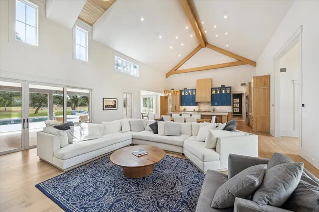 a living room with furniture wooden floor and a large window