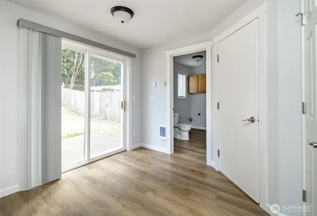 a view of a big room with wooden floor and windows