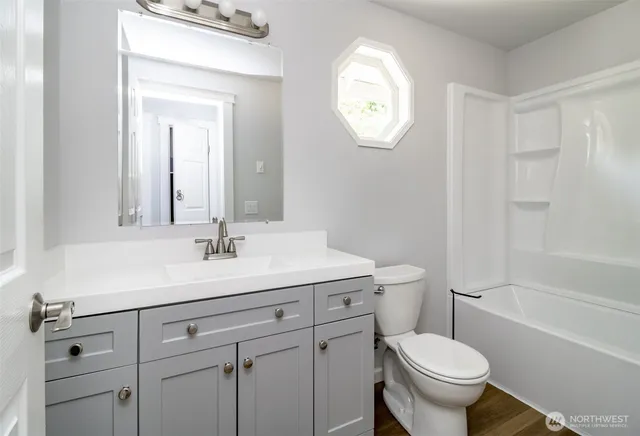 a bathroom with a toilet a sink and mirror