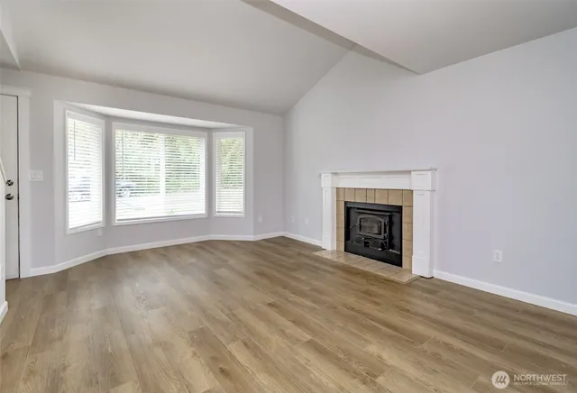 a view of an empty room with a window and fireplace