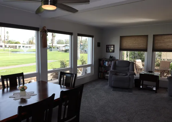 a living room with furniture and floor to ceiling windows