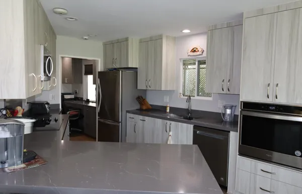a kitchen with stainless steel appliances granite countertop a refrigerator stove and sink