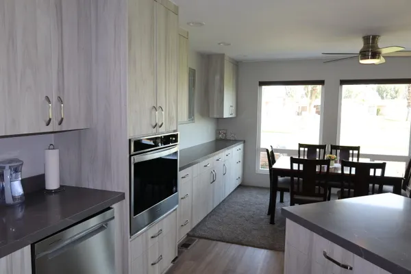 a kitchen with granite countertop a sink dining table and chairs