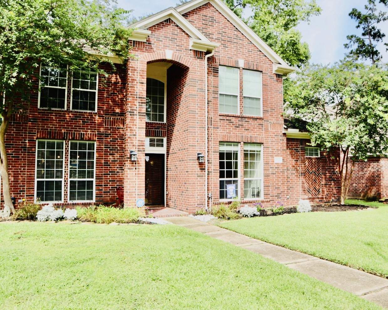 19114 Emory Trail Spring, TX 77388 - Photo 2 of 32 A charming two-story brick home with large windows, a well-maintained lawn, and mature trees. The entryway features a covered porch, creating an inviting first impression.