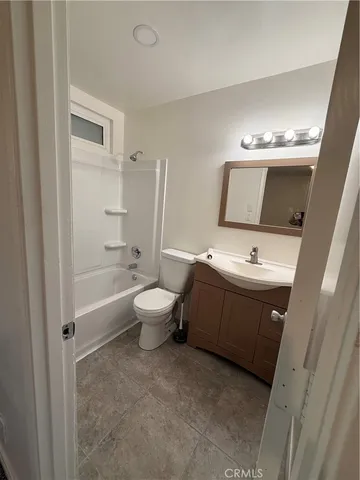 a spacious bathroom with a toilet sink and mirror