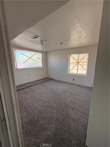 an empty room with windows and closet