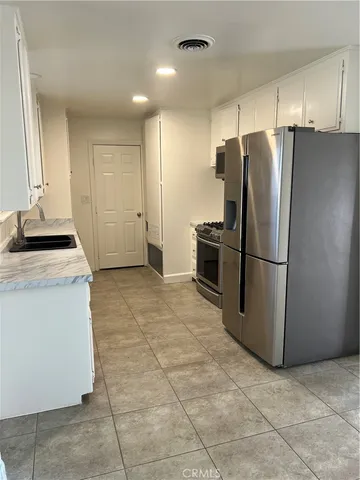 a kitchen with a refrigerator and a stove top oven
