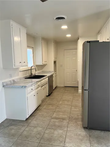 a kitchen with a sink cabinets and refrigerator