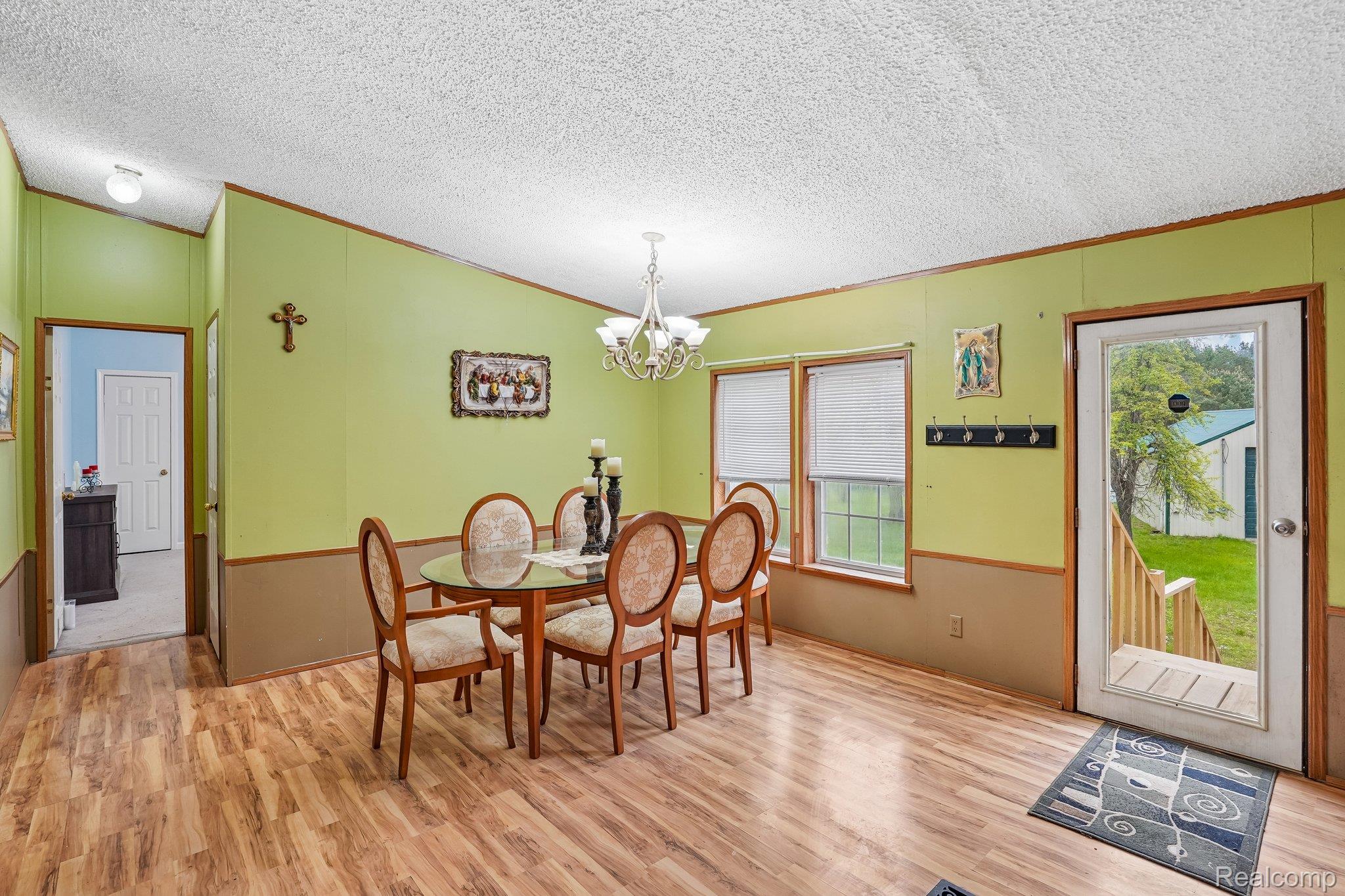 3363 North Branch Road North Branch, MI 48461 - Photo 10 of 38 Dining area featuring light wood-type flooring, ornamental molding, and suspended lighting