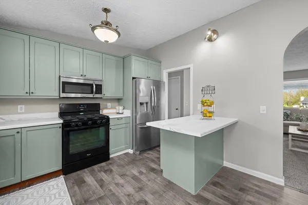 a kitchen with a sink stainless steel appliances and a window