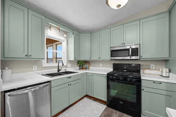 a kitchen with a sink stove and microwave