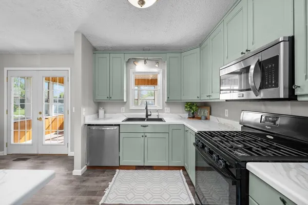 a kitchen with stainless steel appliances granite countertop a stove a sink and a microwave