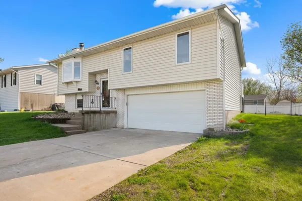 a view of a house with a yard and a garage