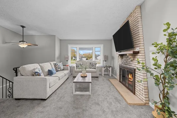 a living room with furniture a flat screen tv and a fireplace