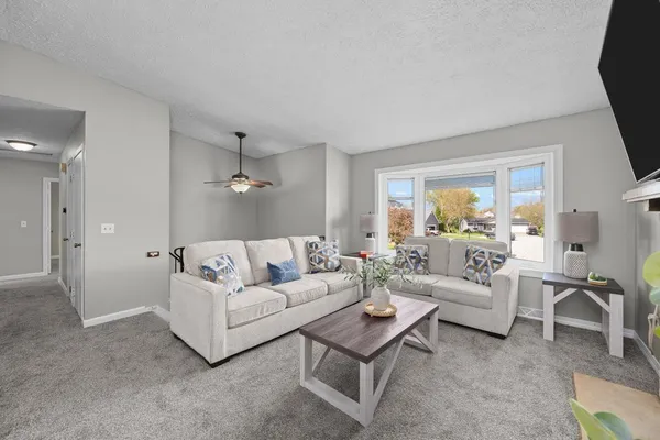 a living room with furniture white walls and a flat screen tv