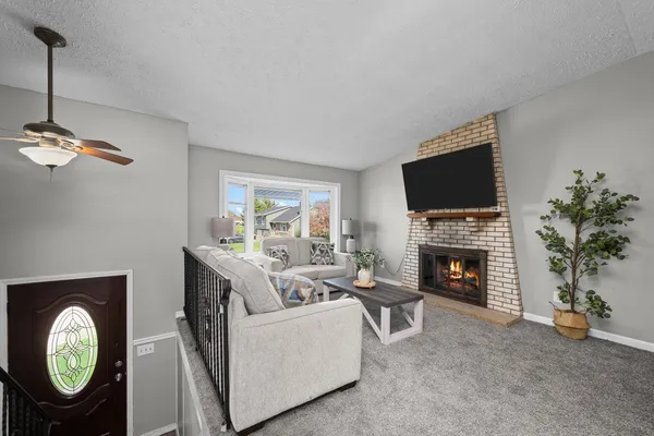 a living room with furniture a fireplace and a flat screen tv