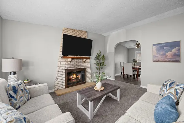 a living room with furniture a flat screen tv and a fireplace
