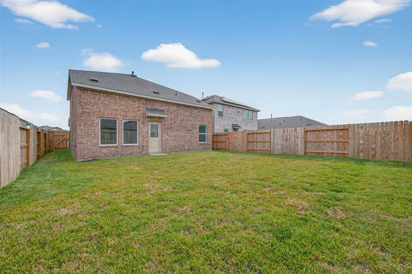 a view of a backyard with plants and wooden fence