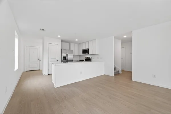 a view of a kitchen with refrigerator and white cabinets