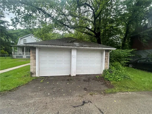a front view of house with a garden
