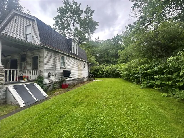 a view of backyard of house with deck and outdoor seating