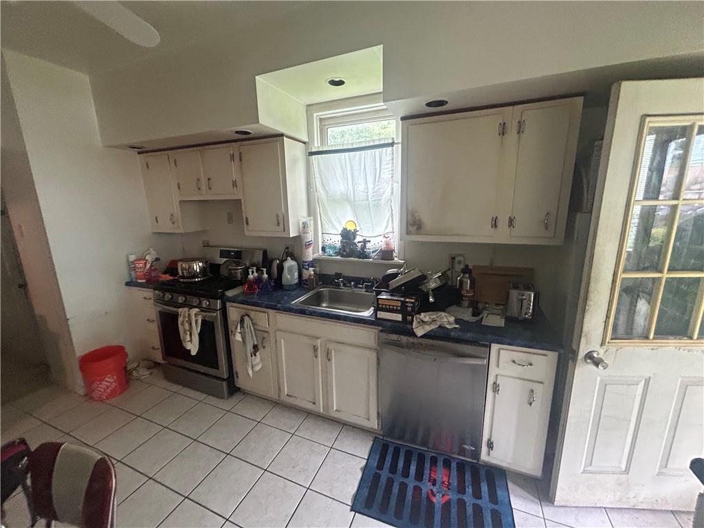 108 Leneake Street Turtle Creek, PA 15145 - Photo 6 of 23 a kitchen with a sink stove and cabinets