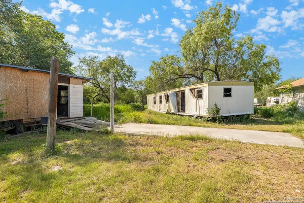 a view of a house with a backyard and a tree