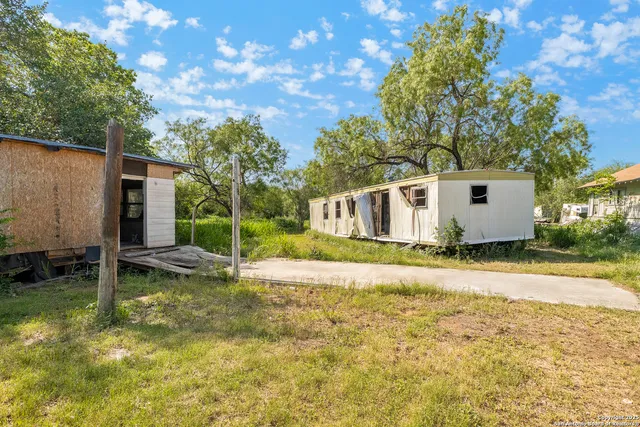 a view of a house with a backyard and a tree