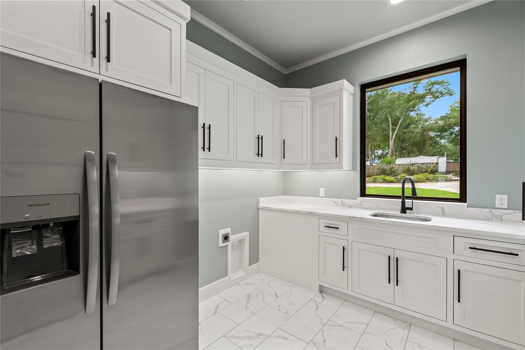 4054 Smothers Road Caney City, TX 75148 - Photo 25 of 40 Functional oversized utility room complete with secondary fridge, large sink, and plentiful storage space.