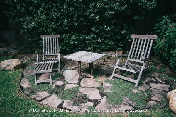 a view of a chairs and table in backyard