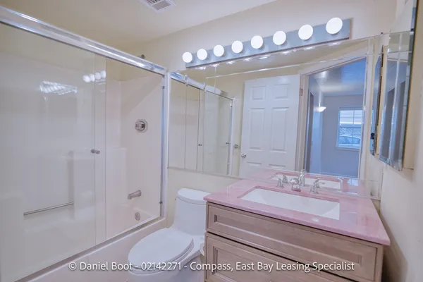 a bathroom with a sink a toilet a mirror and shower