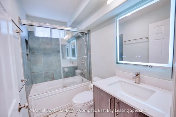 a bathroom with a granite countertop sink toilet tub and shower
