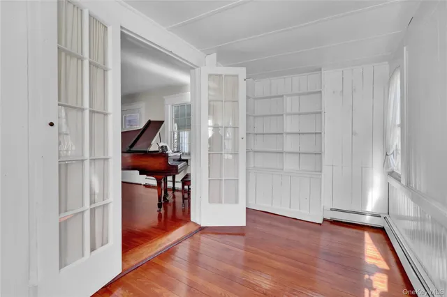 a view of empty room with wooden floor and fan