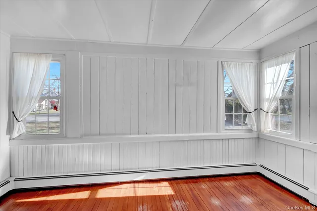a view of a room with wooden floor and a window
