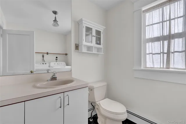 a bathroom with a sink a toilet and a window
