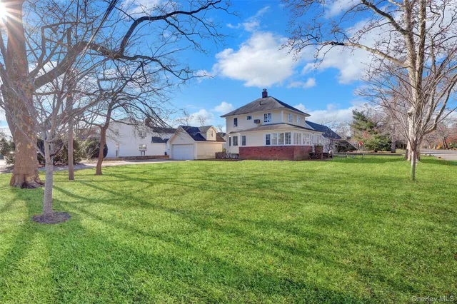 a large tree in front of a house with a yard
