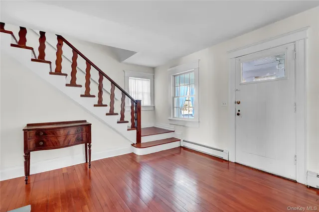 a view of entryway and hall with wooden floor