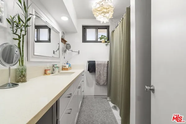 a bathroom with a sink a mirror and a shower