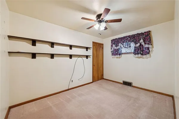 a view of a ceiling fan and a window in a room