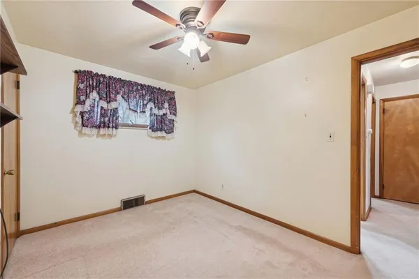 an empty room with a window and a ceiling fan