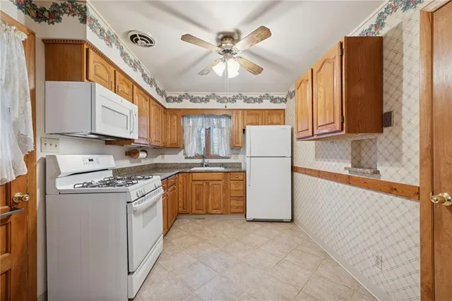 a kitchen with a refrigerator a stove a sink and cabinets