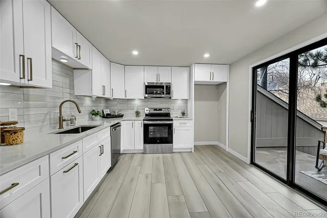 a kitchen with granite countertop a refrigerator stove top oven and sink
