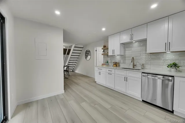 a kitchen with granite countertop white cabinets and white appliances
