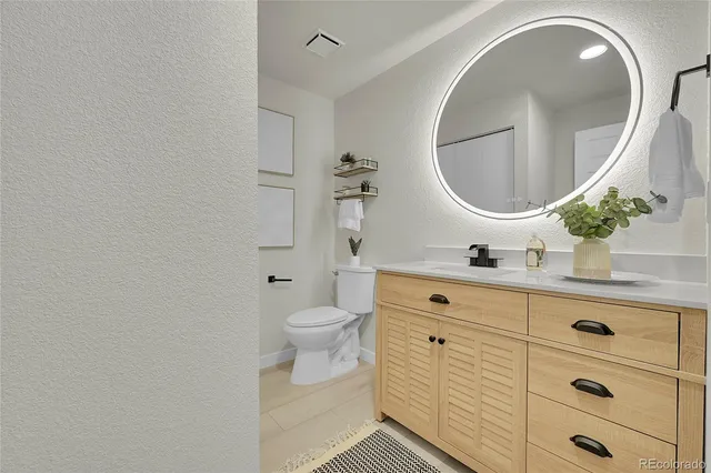 a bathroom with a double vanity sink mirror and toilet