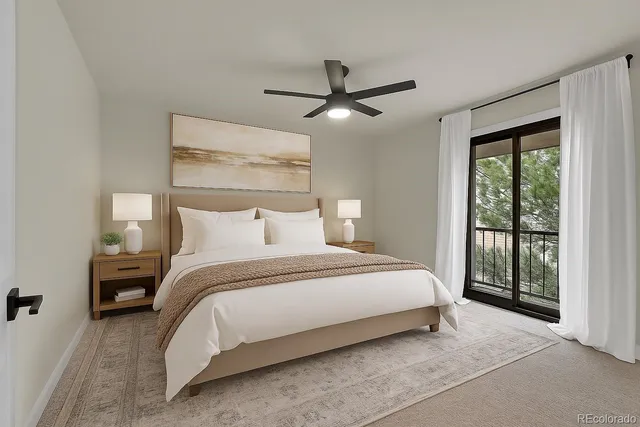a bedroom with a large bed and a chandelier fan
