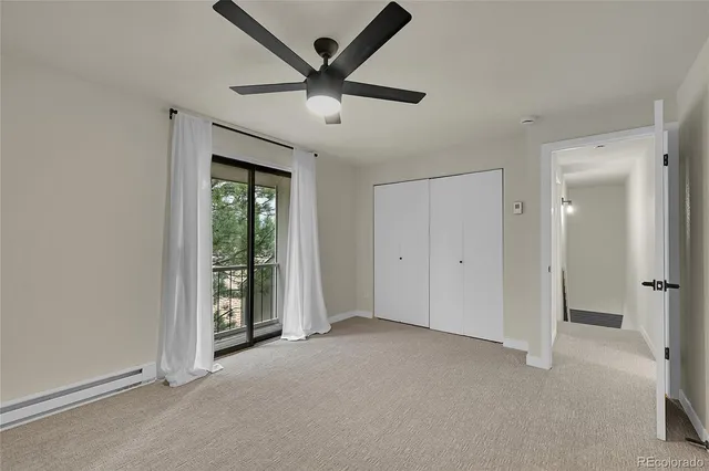an empty room with ceiling fan and window