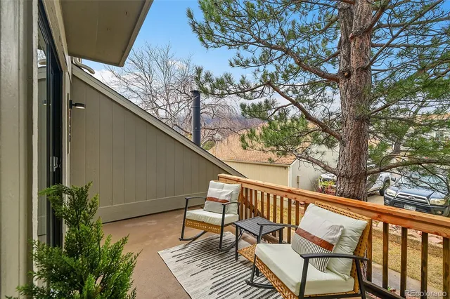 a balcony with wooden floor and some trees