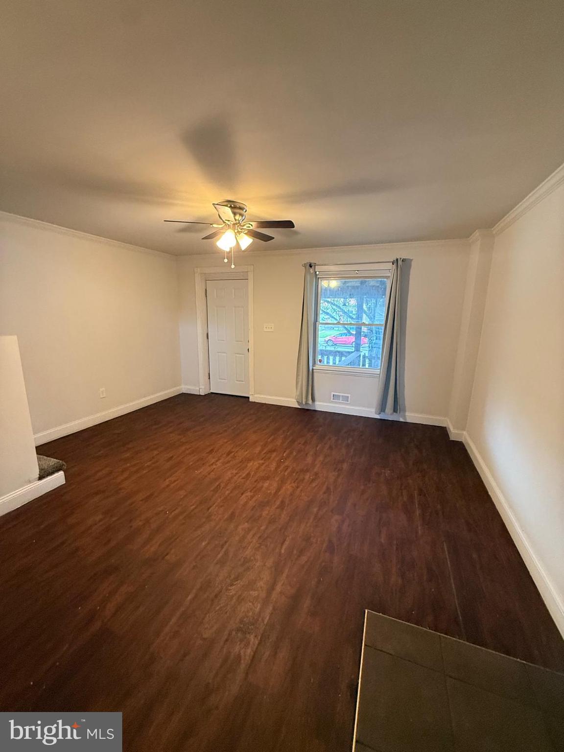 415 Grovethorn Road Baltimore, MD 21220 - Photo 4 of 16 an empty room with wooden floor fan and windows