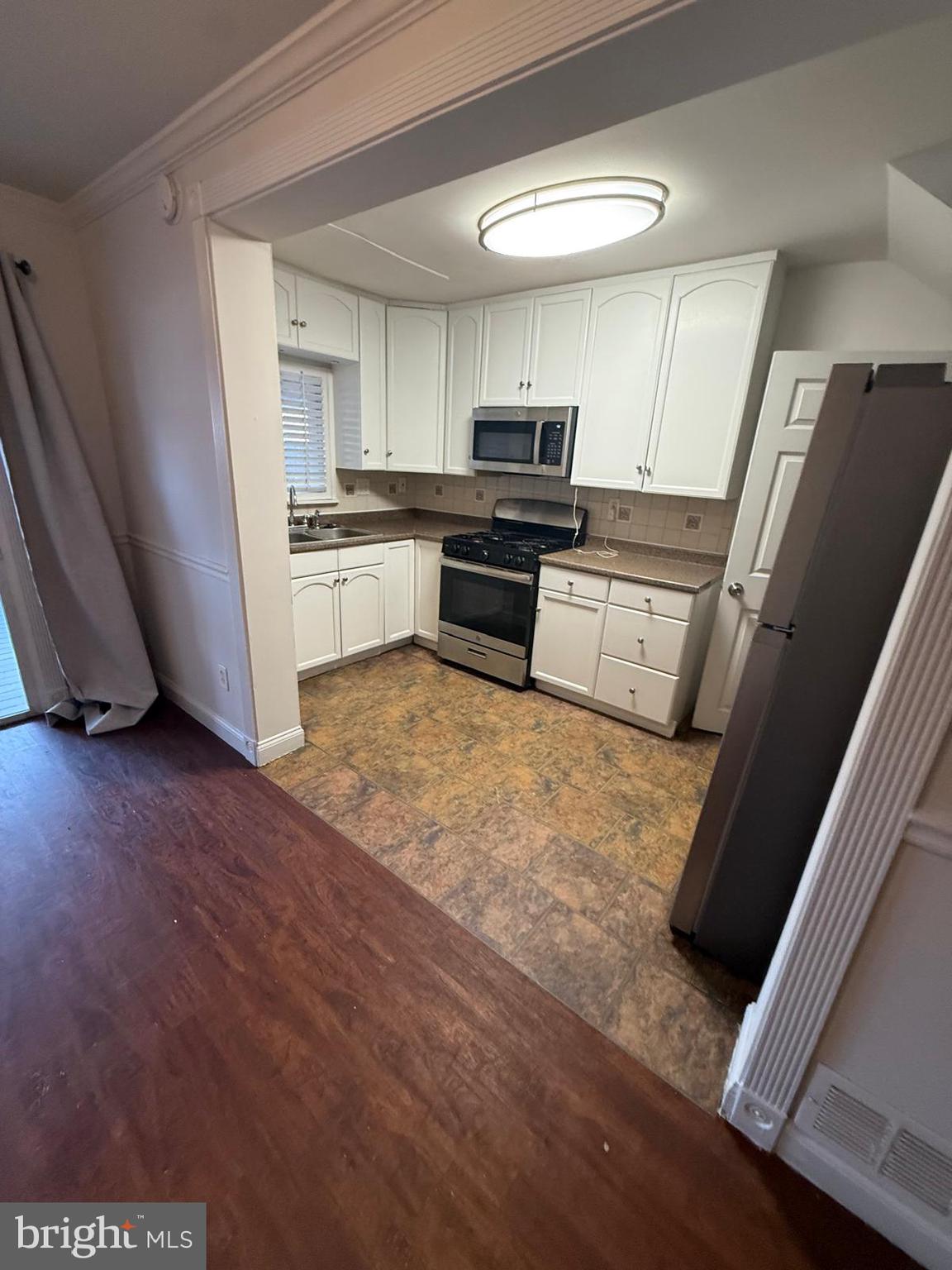 415 Grovethorn Road Baltimore, MD 21220 - Photo 5 of 16 a kitchen with granite countertop a refrigerator sink and microwave
